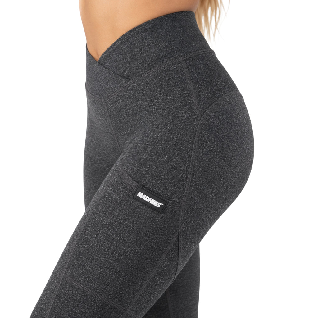 Madness Essential Leggings in Charcoal Grey featuring a crossover high-waisted waistband, side pocket, sculpting seams, and premium stretch fabric shown from front, side, and back.