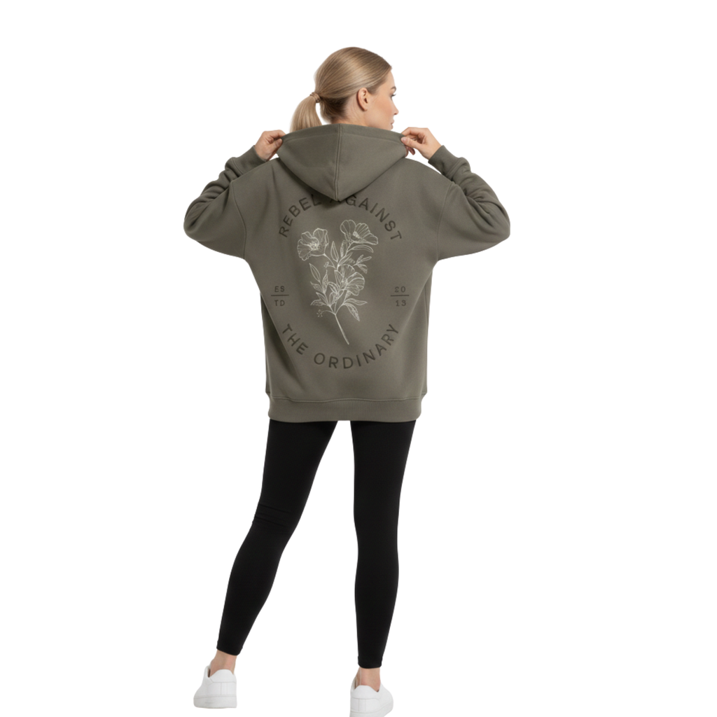 Oversized premium cotton 350GSM hoodie in grey. Front features an arched tonal logo, and the back shows a large floral graphic with "Rebel Against The Ordinary" text. Premium boxy fit streetwear for a structured silhouette.